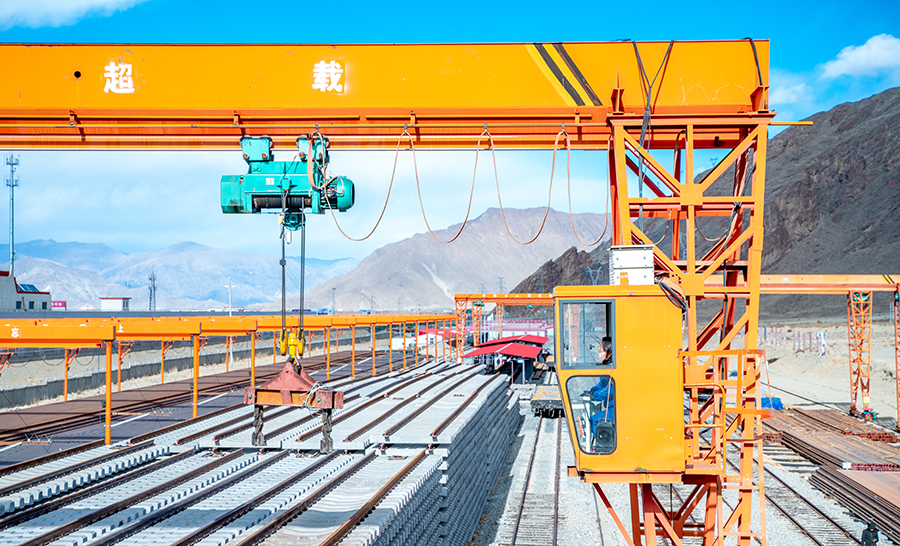 圖為女職工袁芳在高空中，用龍門吊將臺位上的軌排做調整。（丁慶濱 攝）