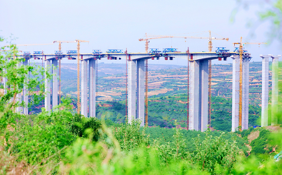 建設者對合龍段施工前采取頂推施工，采用泵管長達216米地泵澆注混凝土，確保了節點目標順利實現。圖為穿越在“青紗帳”中的黃蒲高速控制性工程——石堡川河特大橋。（劉斌斌 攝）