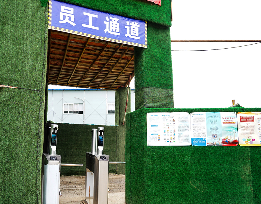 “攔住”張師傅的是中國鐵建所屬中鐵二十五局二公司南京仙林智谷項目部防疫檢測口新配備的刷臉設備?！爱敶蠹掖髦谡诌M入工區、項目部入口時，無須摘下口罩，和往常一樣刷臉就能通過門禁?！睋榻B，這個設備可對佩戴口罩后的人臉進行準確識別，驗證成功后,自動發出信號打開門禁或閘機，記錄考勤信息；對未佩戴口罩或口罩佩戴不規范人員，拒絕通過，并報警提示值班人員。圖為值守在員工通道上的人臉識別系統。（王云海 攝） 