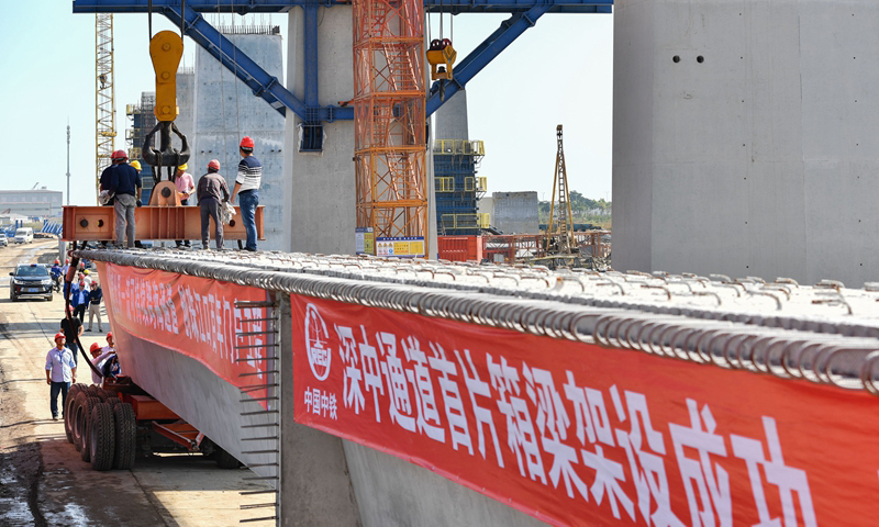 11月21日，中鐵大橋局施工人員在深（圳）中（山）通道西側(cè)中山市翠亨新區(qū)成功架設(shè)一片長(zhǎng)40米、重160噸的箱梁，這也是深中通道全線架設(shè)的第一片箱梁。圖為中鐵大橋局施工人員在中山市翠亨新區(qū)架設(shè)深中通道首片箱梁。（新華社記者 劉大偉 攝）