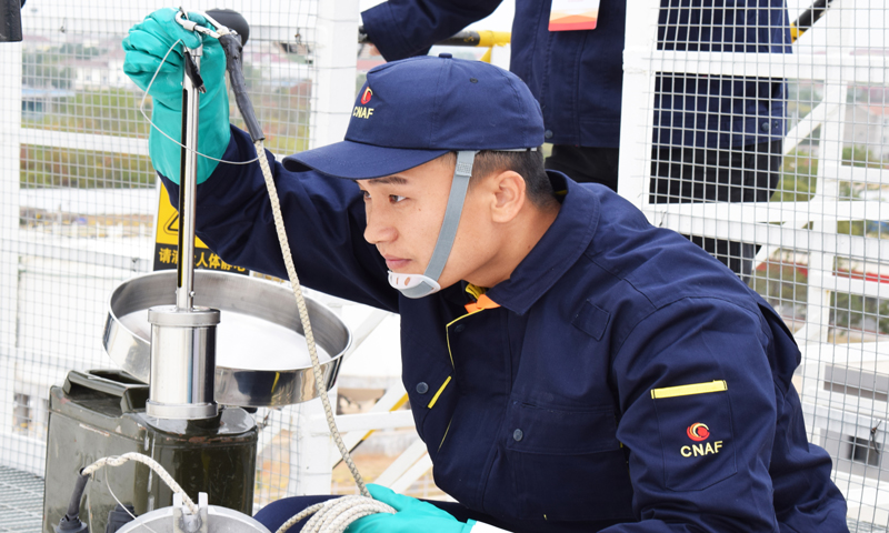 圖為選手測量罐內油品油溫。 