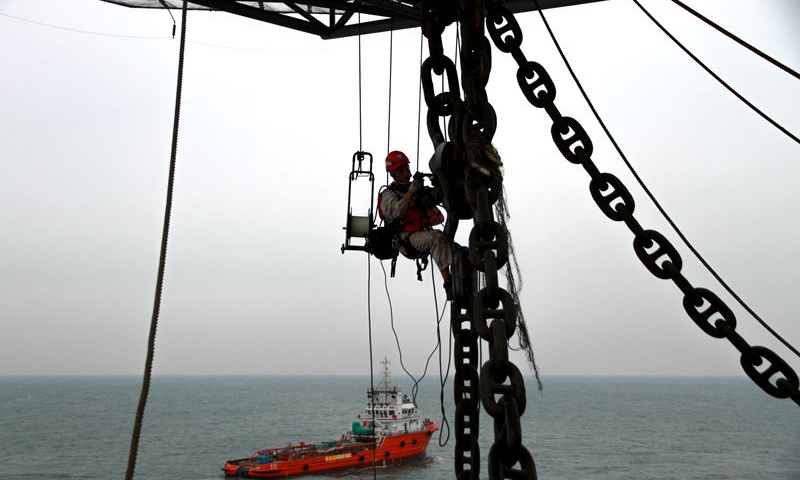 圖為現(xiàn)場(chǎng)作業(yè)人員懸掛高空，對(duì)龍須鏈進(jìn)行探傷檢測(cè)。