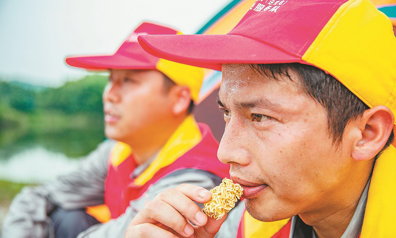 安徽省池州青陽(yáng)山區(qū)特高壓密集通道的運(yùn)檢工作，由國(guó)網(wǎng)安徽電力有限公司送變電工程公司運(yùn)檢站36名工作人員承擔(dān)。圖為巡檢過(guò)程中，工作人員吃干泡面充饑。