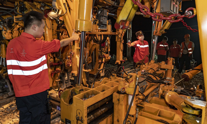 圖為7月19日凌晨，中鐵十一局三公司技術人員在指揮大型搗固車，對新鋪設的道岔進行大機養護。（新華社記者 杜華舉 攝）