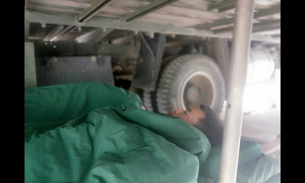 目前，中國安能第三工程局工作人員已奮戰(zhàn)多日，他們不僅晝夜施工，每天二十四小時(shí)兩班倒，還要在山里與烈日、冰雨和風(fēng)沙抗?fàn)帲c蚊蟲戰(zhàn)斗。他們不怕吃苦、不畏艱難，用實(shí)際行動(dòng)展現(xiàn)了央企的戰(zhàn)斗精神和過硬作風(fēng)。圖為6月21日，由于天氣炎熱，夜班人員倒班回來在車底下休息。