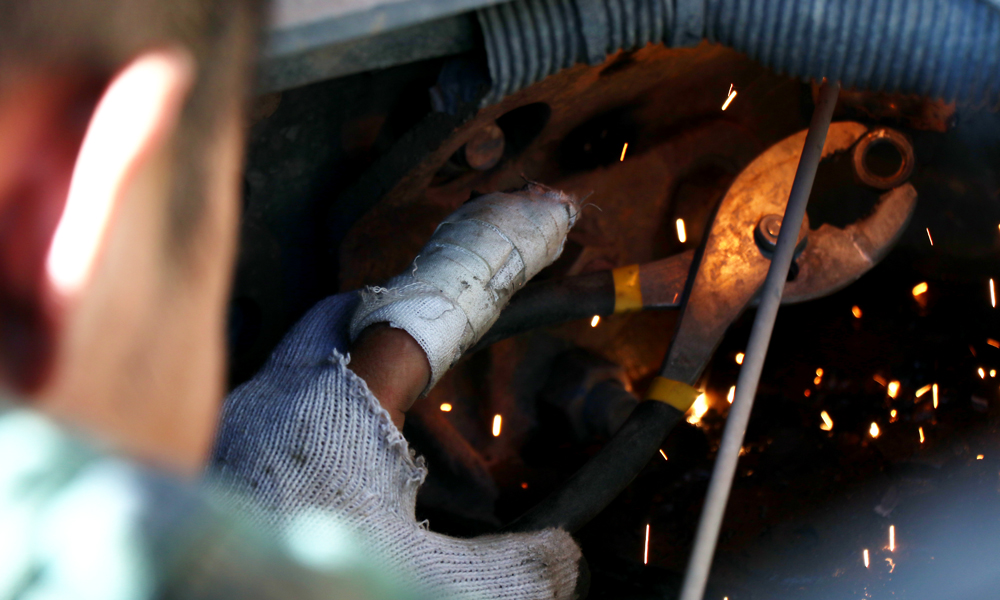 現(xiàn)場施工多半為臨水臨坡作業(yè)，在施工過程中，右岸滑坡體隨時(shí)有垮塌風(fēng)險(xiǎn)，滾石等經(jīng)常滑落，加之需夜間施工，危險(xiǎn)系數(shù)較高。圖為6月24日，修理工人左手受傷，仍堅(jiān)守工作崗位。（李明 攝）