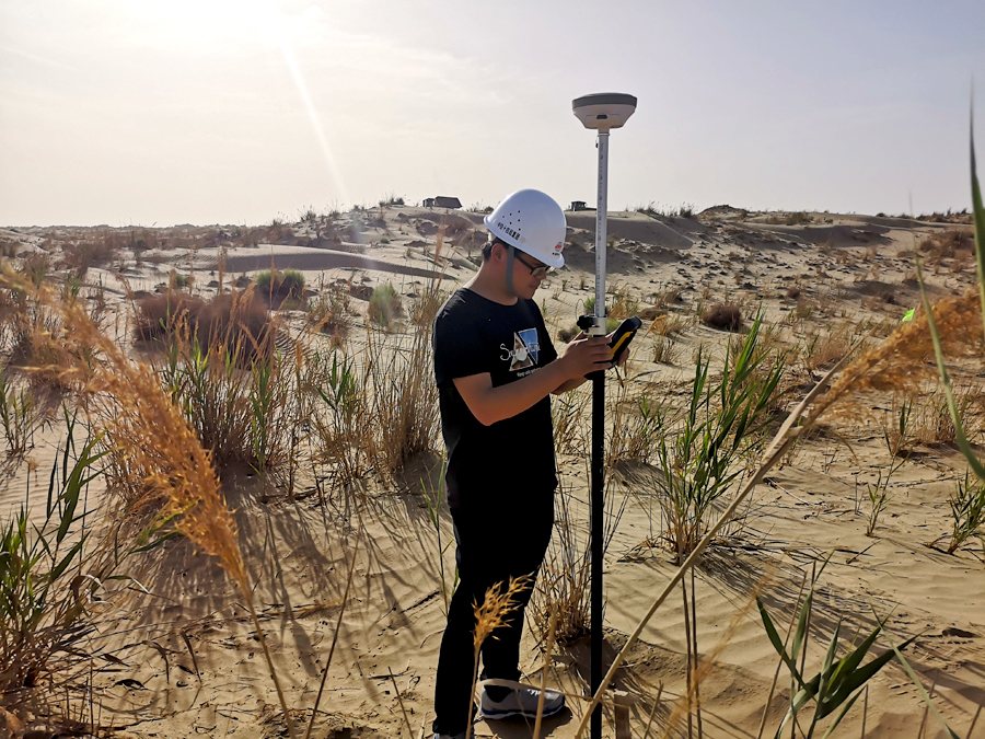 為確保安全優(yōu)質(zhì)高效地完成建設(shè)任務(wù)，中鐵十四局調(diào)集具有沙漠施工經(jīng)驗(yàn)的管理和施工人員，借鑒額哈鐵路建設(shè)經(jīng)驗(yàn)，成立課題攻關(guān)小組。全體建設(shè)者頂著漫天風(fēng)沙在高達(dá)45攝氏度的環(huán)境中，僅用21天就完成了征地手續(xù)、電力引入、水源選取和便道拉通等工作，為加快和若鐵路建設(shè)打下堅實(shí)基礎(chǔ)。圖為中鐵十四局和若鐵路員工在塔克拉瑪干沙漠里進(jìn)行測量工作。