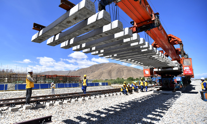 作為我國(guó)進(jìn)藏鐵路的重要組成部分，拉林鐵路預(yù)計(jì)2021年建成通車，屆時(shí)不僅將有效改善我國(guó)區(qū)域鐵路網(wǎng)布局，還對(duì)帶動(dòng)沿線發(fā)展經(jīng)濟(jì)、改善民生、促進(jìn)區(qū)內(nèi)外互聯(lián)互通等具有重要意義。圖為6月6日，負(fù)責(zé)鋪軌的中鐵十一局集團(tuán)的建設(shè)者在現(xiàn)場(chǎng)作業(yè)。（新華社記者 覺(jué)果 攝）