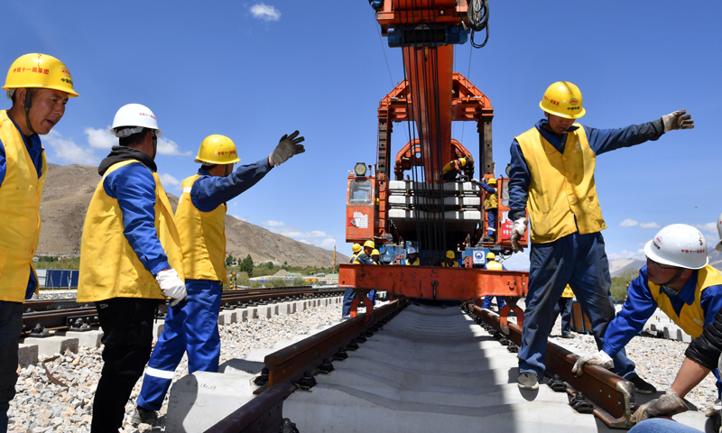 圖為6月6日，負(fù)責(zé)鋪軌的中鐵十一局集團(tuán)的建設(shè)者在現(xiàn)場(chǎng)作業(yè)。（新華社記者 覺(jué)果 攝）