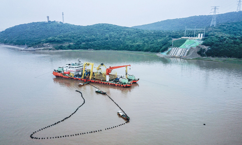 圖為6月2日，最后一段海底電纜從海纜施工船上緩緩?fù)舷蛑凵酱簌i山島的終端站。（新華社記者 徐昱 攝）