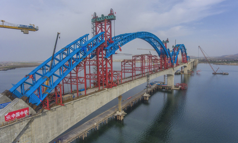 圖為3月11日，施工人員在漢十高鐵崔家營漢江特大橋主拱上進行抬升作業。新華社發（楊東 攝）