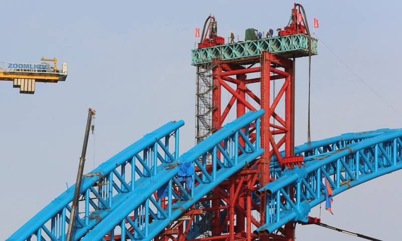 圖為3月11日，施工人員在漢十高鐵崔家營漢江特大橋主拱上進行抬升作業。新華社發（楊東 攝）