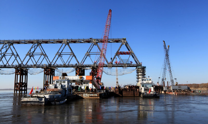 10月13日上午，中俄同江－下列寧斯闊耶鐵路橋重要組成部分——黑龍江特大橋中方最后一吊鋼梁安裝到位，標志著同江中俄鐵路大橋中方段主體工程全部完成。圖為10月13日拍攝的同江中俄鐵路大橋的中方建設部分。（新華社記者 馬知遙 攝）