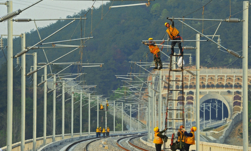 杭黃高鐵浙江段自2016年10月全面啟動電氣化施工以來，中鐵電氣化局集團公司針對該路段隧道和橋梁眾多、沿線交叉作業(yè)干擾頻繁等情況，嚴謹編制安全施工方案，精心組織施工人員施工，努力確保該段高鐵在2018年6月底完成電氣化主體工程。圖為3月30日，中鐵電氣化局集團公司施工人員在杭黃高鐵浙江桐廬段調(diào)整接觸網(wǎng)導(dǎo)線。（新華社記者 譚進 攝）