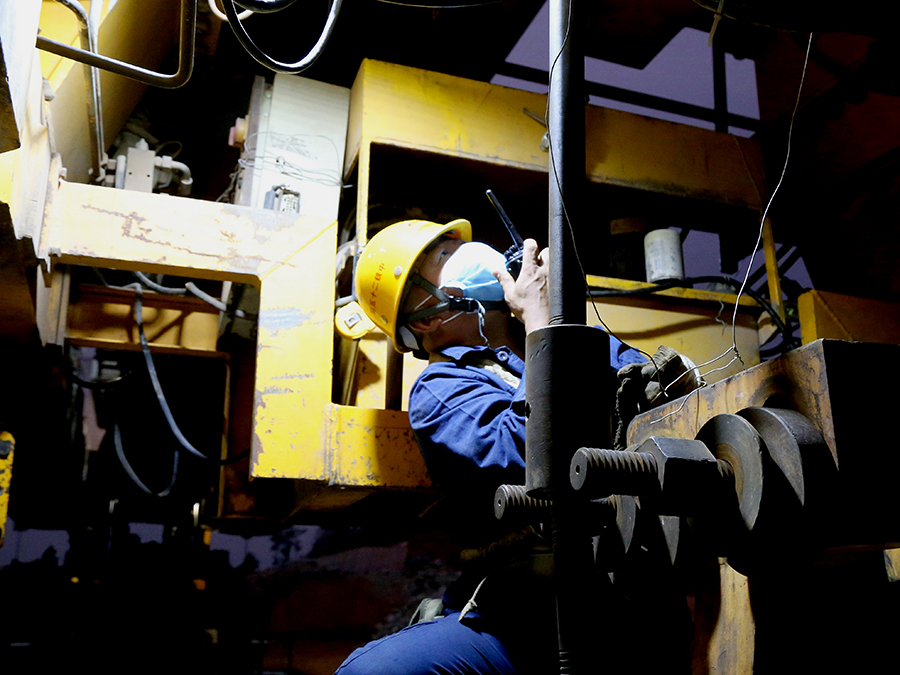 由于箱梁從制梁場到工地的距離達到5.6公里，且運送過程中離左右兩側擋砟墻只有一個人的寬度，稍有不慎就會發生剮蹭，路途還穿越兩座隧道，運梁時箱梁翼緣板距離隧道壁僅有10厘米，極容易導致安全事故。圖為現場指揮人員邊觀察邊指揮。（陸新健 攝）