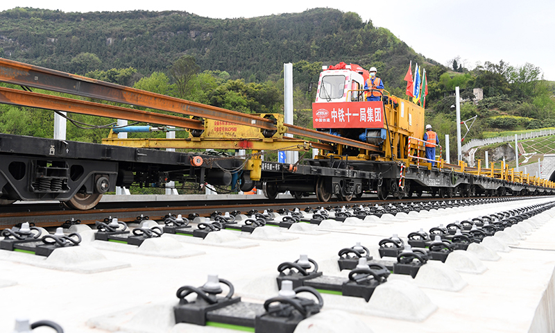 3月17日，“走單線鋪雙線”的施工技術(shù)在鄭萬高鐵重慶段鋪軌作業(yè)現(xiàn)場正式投入運(yùn)用。這一技術(shù)填補(bǔ)了我國高鐵機(jī)械化跨線鋪軌作業(yè)技術(shù)空白。圖為BLCP500型本鄰兩線長軌鋪設(shè)機(jī)組進(jìn)行機(jī)械化跨線鋪軌作業(yè)。（新華社記者 唐奕 攝）