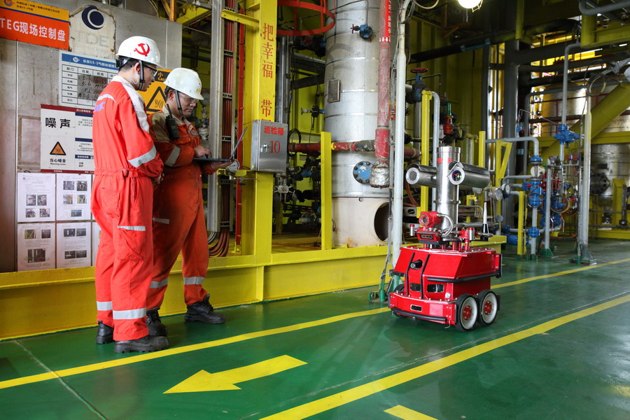 圖為氣田工作人員對(duì)智能機(jī)器人進(jìn)行調(diào)試。