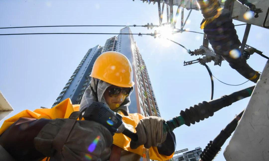 國網重慶電力科學合理布置搶修站點158個，組織國家電網紅巖共產黨員服務隊113支、應急搶修隊伍139支，調配搶修人員5652人、應急搶修車730臺、應急發電車51臺，在遭受外力破壞、設備故障、極端天氣等造成突發停電時，迅速開展故障搶修和應急保電，全力做好電力迎峰度夏保障工作。圖為國網重慶電力帶電作業人員在烈日下拆除故障線路。