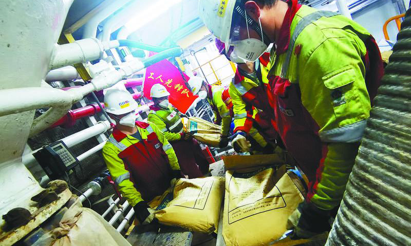 初秋，渤海灣秋風正勁。中國海油“挑戰者”鉆井平臺上，“新優快”試點項目最后一口井正在下套管作業。圖為二開作業期間需要大量泥漿，平臺上的工人先鋒隊迅速集結，手動搬運泥漿材料。