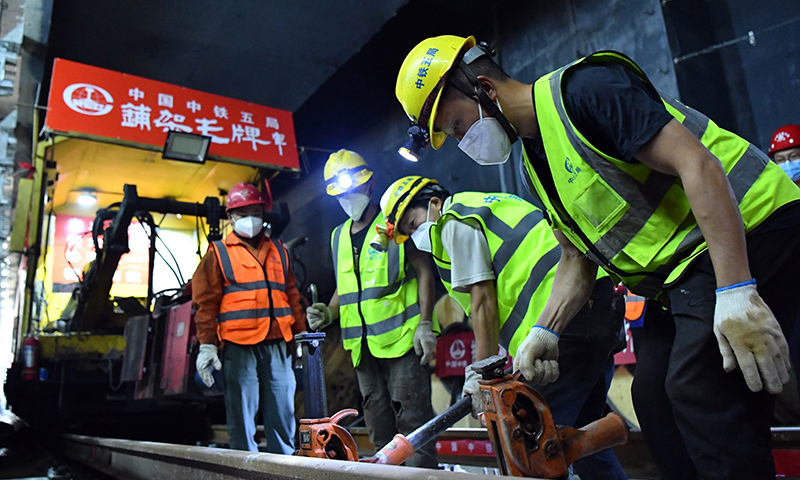 近日，鄭（州）許（昌）市域鐵路鄭州段軌道貫通。鄭許市域鐵路工程又稱鄭州機場至許昌市城市軌道交通工程，是一條連接鄭州市與許昌市的城市軌道交通系統，全長67.13公里，設計時速120公里。圖為中鐵五局工人在鄭許市域鐵路鄭州段進行打磨軌道作業。（新華社記者 李嘉南 攝）