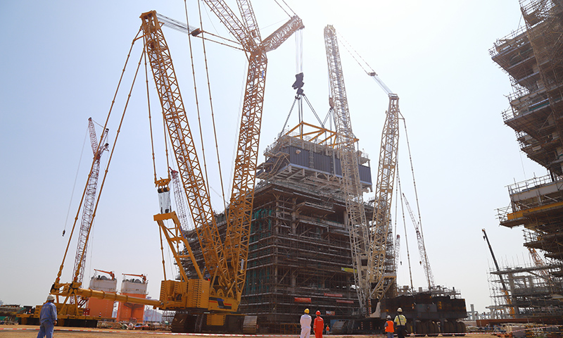 在中國海油海油工程建造事業部青島場地加拿大LNG項目模塊總裝區，經過施工人員多天連續奮戰，加拿大LNG項目第二個Mini E-House（電氣間）精準就位于A1EB模塊指定位置。圖為Mini E-House（電氣間）吊裝現場。