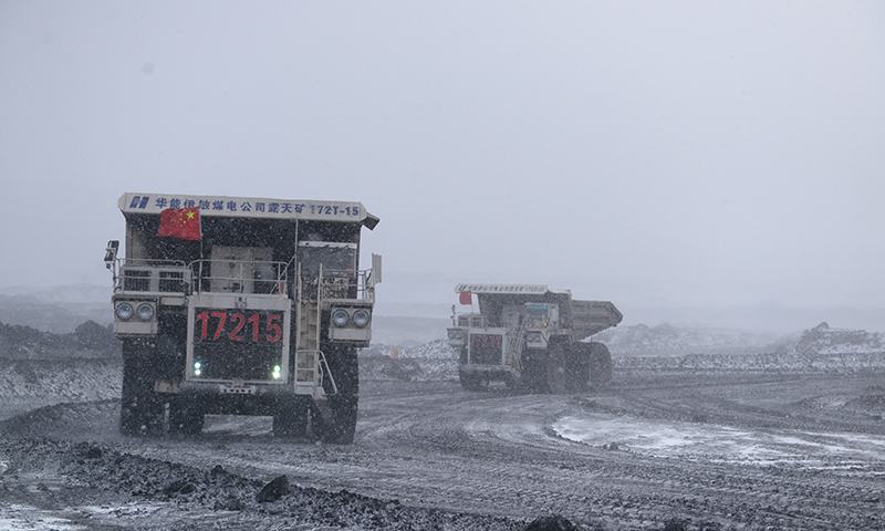 圖為華能伊敏露天礦自卸卡車風(fēng)雪中保煤炭運(yùn)輸。