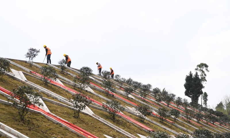 線路開通后將大幅壓縮重慶至昆明的鐵路旅行時間，改善沿線群眾出行條件，促進沿線經濟社會高質量發展。圖為2月9日，施工人員在中鐵十一局承建的渝昆高鐵川渝段馬家屋基特大橋邊坡治理項目作業。（新華社記者 王全超 攝）