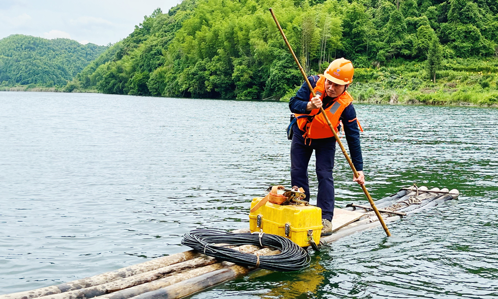 為解決網絡障礙問題，中國電信安徽祁門分公司維護人員撐竹排加步行，趕往用戶家中維修。