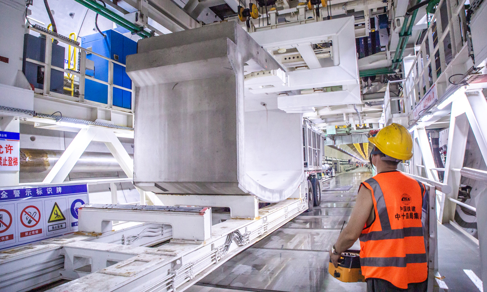 廣湛高鐵正線全長約401千米，設(shè)計(jì)行車時(shí)速350千米，為廣東省建設(shè)里程最長、投資最大的高鐵項(xiàng)目。湛江灣海底隧道是全線控制性工程，主航道長195米，最大水深20.8米，最低點(diǎn)覆土16.7米，最大水壓6巴，相當(dāng)于在一個(gè)指甲蓋大小的面積上承受6公斤的壓力。目前，“永興號(hào)”盾構(gòu)機(jī)已累計(jì)掘進(jìn)進(jìn)尺2770米，順利穿越湛江灣最深處，預(yù)計(jì)年底完成海域段整體掘進(jìn)施工任務(wù)。圖為工作人員正在吊裝箱涵。