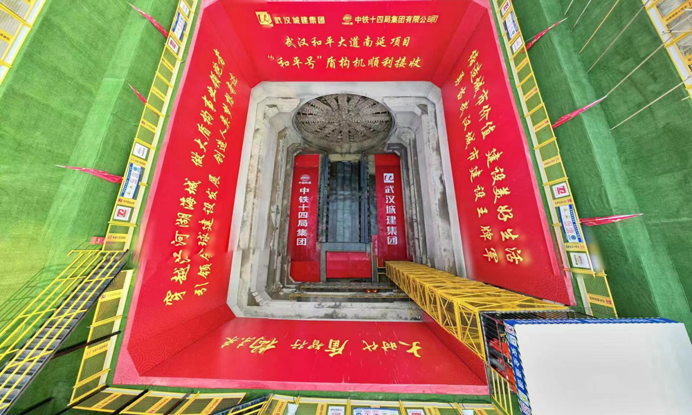 和平大道南延工程位于武漢市武昌區(qū)，北接和平大道、南連武金堤路，通過武昌古城、下穿蛇山，是貫通武昌順江通道的控制性工程。該工程全長3042米，其中1390米采用開挖直徑為16.03米的泥水平衡盾構(gòu)機(jī)“和平號”施工。該隧道為國內(nèi)最大直徑單管雙層盾構(gòu)隧道，雙向6車道，設(shè)計時速50公里。圖為“和平號”盾構(gòu)機(jī)出洞現(xiàn)場航拍。