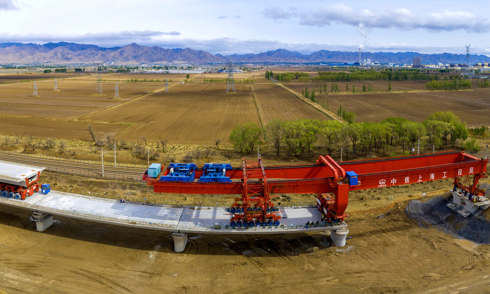 近日，中國中鐵旗下中鐵上海局承建的包（頭）銀（川）高鐵跨萬甘鐵路特大橋完成箱梁架設(shè)，標志著包銀高鐵內(nèi)蒙古段首座跨鐵路特大橋主體工程全部結(jié)束。圖為包銀高鐵跨萬甘鐵路特大橋箱梁架設(shè)施工現(xiàn)場。