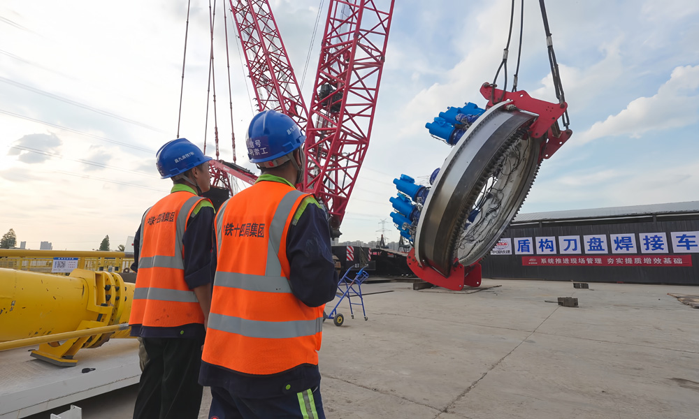 為確保10月底盾構(gòu)始發(fā)這一重大節(jié)點(diǎn)，300多名施工人員在節(jié)日期間堅(jiān)守崗位，奮戰(zhàn)在一線。該隧道全長6.379公里，采用“盾構(gòu)+明挖”進(jìn)行施工，其中盾構(gòu)段長4.4公里。圖為施工人員為主驅(qū)動(dòng)下井做準(zhǔn)備。