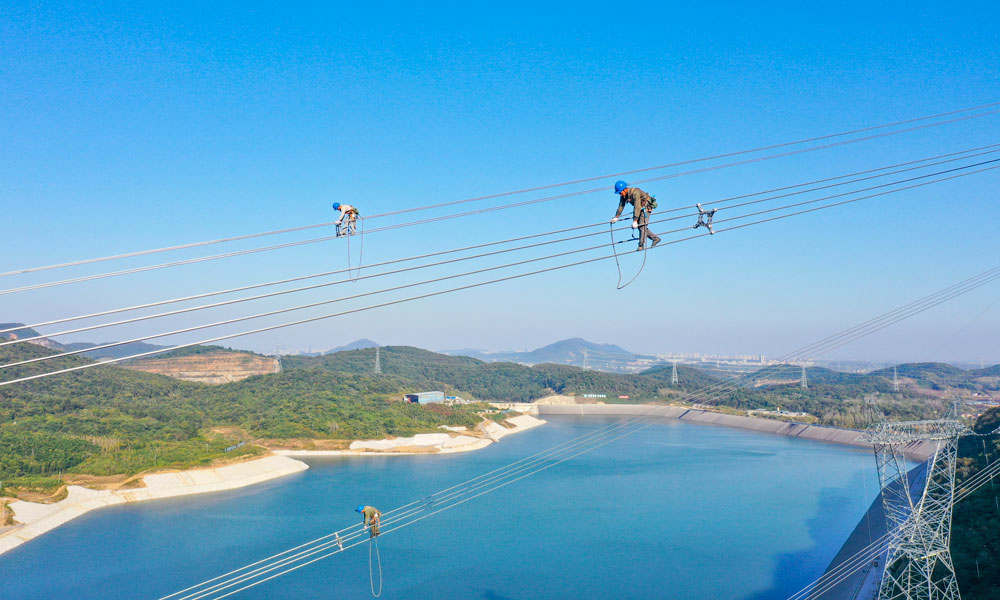 國家電網江蘇省送變電有限公司輸電人員在高空走線驗收消缺。