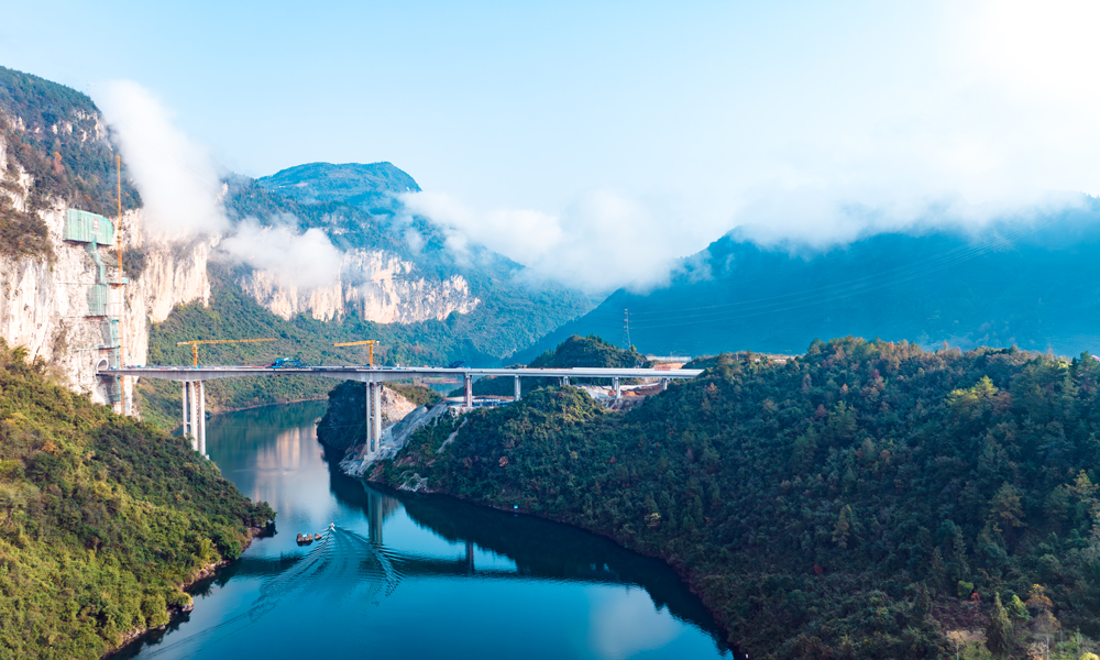 渝湘復(fù)線高速公路總里程280公里，由巴南至彭水、彭水至酉陽、武隆至道真3條路組成，平均橋隧比80%。圖為阿蓬江大橋施工現(xiàn)場(chǎng)航拍側(cè)景。