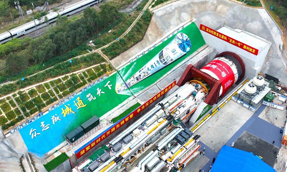 “龍崗一號”盾構機開挖直徑為14.33米，整機全長約122米，總重約3850噸。針對該項目地質特點和施工風險，研發團隊充分發揮大盾構技術優勢，結合工程實際和豐富施工經驗，從設備結構、排渣方式等方面進行了針對性設計，極大提高了“龍崗一號”盾構機在復雜條件下的適應性，為后續盾構安全高效掘進奠定了堅實基礎。圖為“龍崗一號”盾構機始發現場。