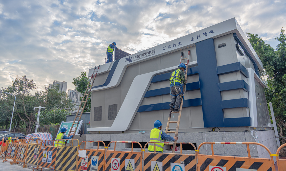 近日，南方電網(wǎng)首座全預(yù)裝近零碳景觀配電站在深圳投運(yùn)。因其外形酷似魔方，也被稱為“電力魔方”。它是將預(yù)制艙、標(biāo)準(zhǔn)化設(shè)備、零碳裝備、智能傳感器等，在工廠內(nèi)完成標(biāo)準(zhǔn)化預(yù)制生產(chǎn)、集成裝配“一條龍”，最后整站成套交付的產(chǎn)品。現(xiàn)場(chǎng)“搭積木式”拼裝，實(shí)現(xiàn)配電站從“建”到“買”的轉(zhuǎn)型。圖為工作人員在現(xiàn)場(chǎng)進(jìn)行全預(yù)裝近零碳景觀配電站光伏系統(tǒng)安裝。