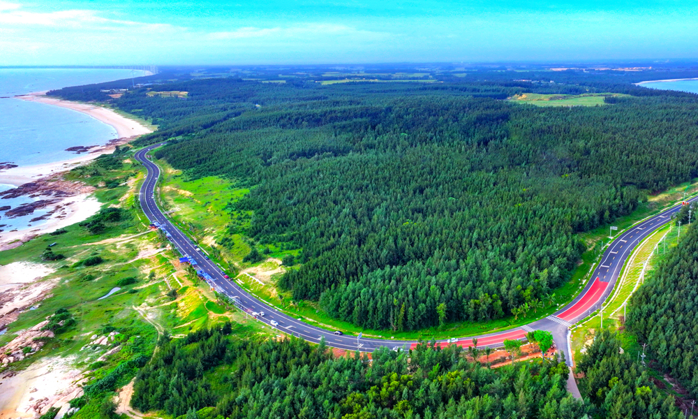 海南環(huán)島旅游公路主線(xiàn)總里程為988公里，其中新建改建段453公里（連接線(xiàn)、支線(xiàn)、魚(yú)骨線(xiàn)等新建改建90公里）、利用段535公里，貫穿海口、文昌、瓊海等沿海12個(gè)市縣。中鐵二局、中鐵北京局承建海南環(huán)島旅游公路文昌段、昌化段、珠碧江段工程，地跨文昌、瓊海、東方、昌江、儋州五地，路線(xiàn)總長(zhǎng)度約218公里；中鐵八局承建公路沿線(xiàn)附屬配套工程，負(fù)責(zé)公路沿線(xiàn)8處養(yǎng)護(hù)工區(qū)房建施工。該項(xiàng)目具有標(biāo)段線(xiàn)路長(zhǎng)、施工組織難度大、沿海受汛期臺(tái)風(fēng)影響大、海域環(huán)保要求高等特點(diǎn)。圖為海南環(huán)島旅游公路木蘭灣。