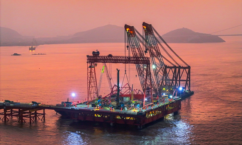 1月7日清晨，甬舟鐵路西堠門公鐵兩用大橋5號主墩超大直徑鉆孔樁灌注施工現場，工人在澆筑最后一根鉆孔樁（無人機照片）。新華社發（姚峰?攝）