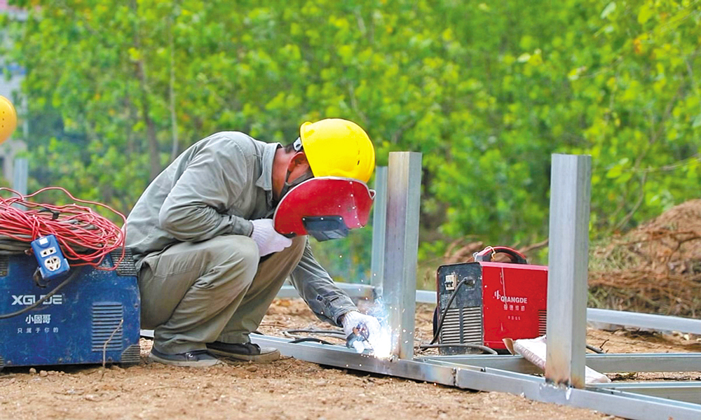 目前，電力搶險人員堅守現(xiàn)場保供電。據(jù)介紹，排水用電需求為26800千瓦。國家電網(wǎng)緊急增派中低壓發(fā)電車38臺，調(diào)撥箱式變壓器32臺、環(huán)網(wǎng)柜2臺、高壓電纜3.8千米、低壓電纜80.48千米。圖為國家電網(wǎng)電力搶險人員焊接箱式變壓器鐵架，為排水點接電做準備。