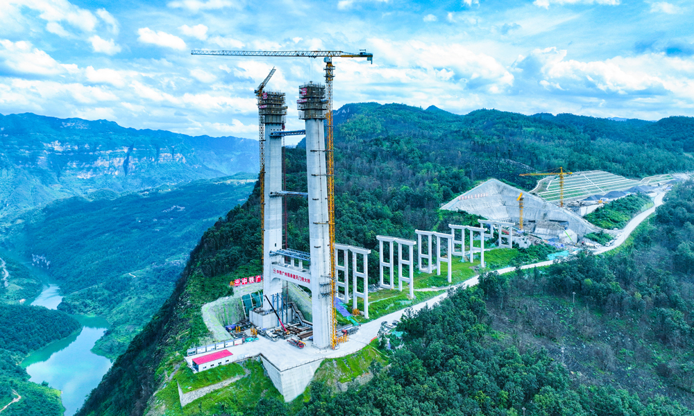 天門特大橋位于六盤水境內，橫跨北盤江大峽谷，全長1553米，主跨820米。大橋橋面至河面高度560米，建成后將成為世界最高雙向六車道鋼桁梁懸索橋。大橋設有2個主塔，安順岸主塔高近200米。此次封頂的盤州岸主塔為薄壁空心門形結構，塔身右肢高為135米、左肢高為127米，設上、下2道橫梁。