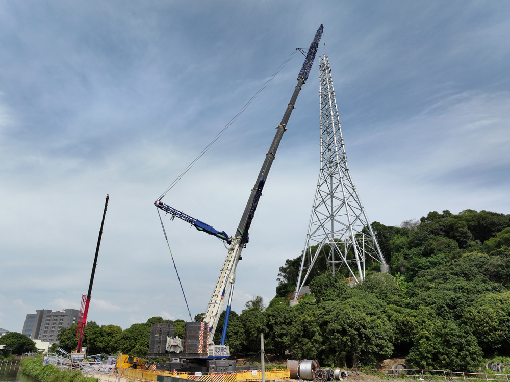 在廣東汕頭500千伏澄海站配套220千伏線路二期工程現(xiàn)場，施工人員應(yīng)用重型起重機整體吊裝鐵塔提升立塔效率。該工程計劃年底前全面投產(chǎn)，完善粵東一帶電網(wǎng)架構(gòu)。