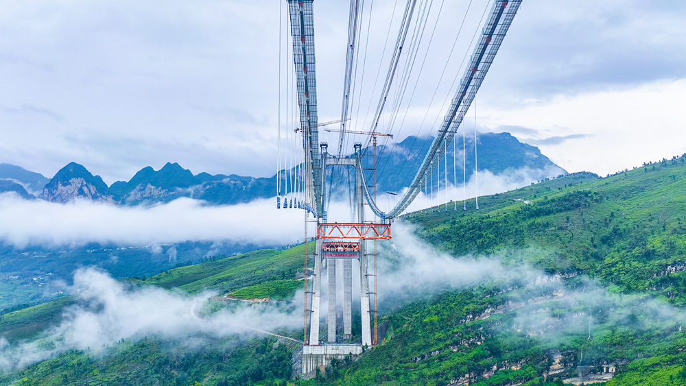 天門特大橋全長1553米，橫跨北盤江峽谷，為主跨820米的單跨鋼桁梁懸索橋，是安盤高速全線重難點工程之一。大橋主塔高近200米，采用鋼筋混凝土門式結(jié)構(gòu)。橋面至河面高度為560米，是目前世界第三高橋，也是世界最高雙向六車道鋼桁梁懸索橋。