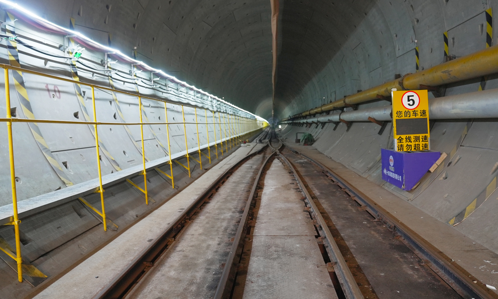 穗莞深城際機前段工程起于已開通的穗莞深城際深圳機場站，終至前海站綜合交通樞紐，線路全長約15.2公里，全線地下敷設，共設西鄉、寶安、前海3座車站，設計時速160公里。其中下穿海域段長度約3.1公里，采用開挖直徑達9.14米的泥水平衡盾構機施工，是全線獨頭掘進距離最長、唯一下穿海域的隧道，是全線環境風險最高的工程。圖為成型后的隧道內景。