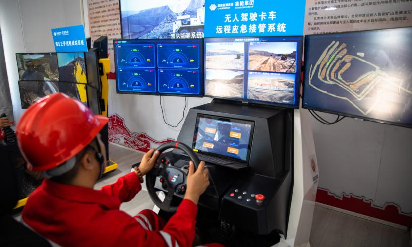 在準能集團黑岱溝露天煤礦智能礦山建設現場指揮中心，技術員正在通過無人駕駛卡車遠程應急接管系統實時監控行車路線。該設備用于對無人駕駛卡車監控和遠程應急接管，可有效保障無人駕駛運輸系統的持續作業，為無人駕駛安全提供保障。該礦運用多編組車輛智能化調度與管理系統，實現三編組無人駕駛卡車同時運行和多車智能協同裝卸，大幅提升了無人作業效率。包文學 攝