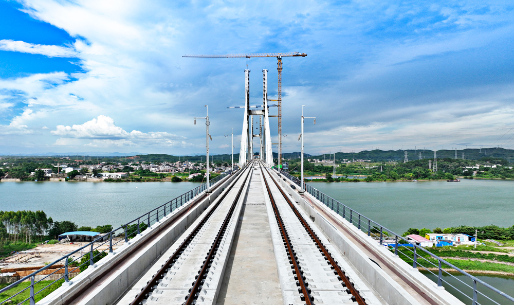 南深高鐵南玉段建成通車后，南寧至玉林的行車時(shí)間將由近2小時(shí)縮短至50分鐘左右，助力廣西實(shí)現(xiàn)“市市通高鐵”目標(biāo)，對廣西打造粵港澳大灣區(qū)重要戰(zhàn)略腹地，進(jìn)一步推動(dòng)廣西北部灣經(jīng)濟(jì)區(qū)和粵港澳大灣區(qū)“兩灣聯(lián)動(dòng)”、實(shí)現(xiàn)珠江—西江經(jīng)濟(jì)帶區(qū)域協(xié)同發(fā)展具有重要意義。圖為已完成鋪軌施工的六景郁江特大橋橋面。