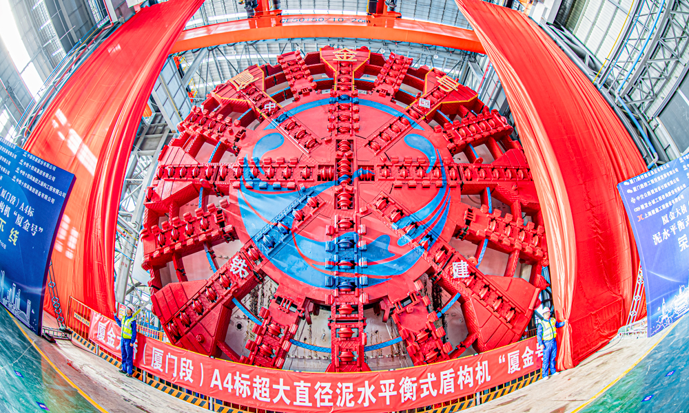 近日，由中國鐵建所屬中鐵十四局參與聯合打造的超大直徑泥水平衡盾構機“廈金號”在江蘇南通下線。該盾構機將應用于廈門至金門大橋（廈門段）主線隧道工程施工。該隧道是福建省在建最大直徑盾構公路隧道。圖為“廈金號” 盾構機下線現場。