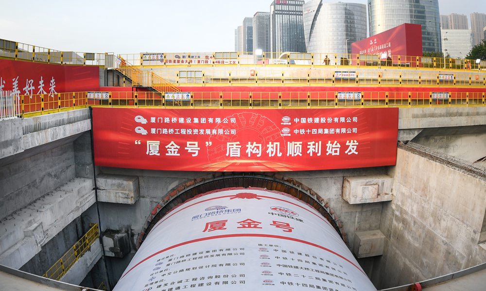 廈金大橋（廈門段）工程起于廈門環島東路與會展北路交叉口，以隧道形式沿環島路向北延伸至觀音山，往東以橋梁形式跨越本島東部海域，終點設互通接入廈門翔安國際機場，主線長17.34公里。其中，環島路隧道長3.29公里，采用盾構、明挖法施工，盾構隧道左右線分別為1.33公里與1.04公里，為雙向六車道，設計時速80公里，由一臺16米級超大直徑盾構機掘進。圖為“廈金號”盾構機始發現場。