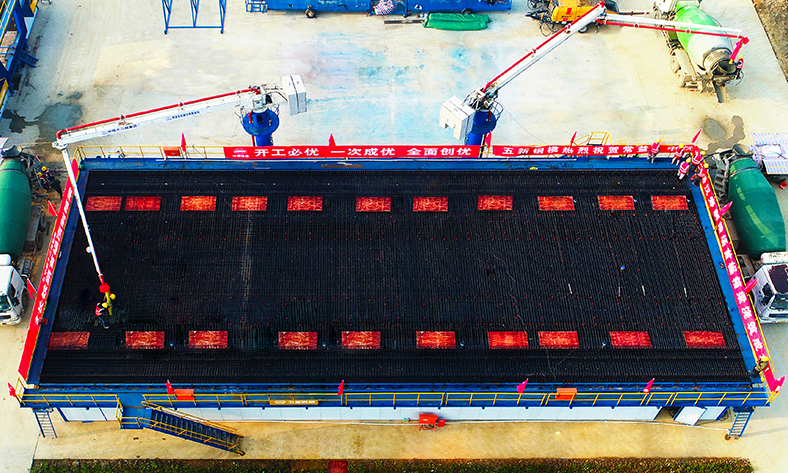 自動(dòng)化生產(chǎn)線讓人員包袱更輕、復(fù)工進(jìn)度更快、防疫物資壓力更小。開工后的制梁現(xiàn)場(chǎng)少有人員走動(dòng)，工人們?cè)诠潭◢徫徊僮髟O(shè)備，管理人員通過遠(yuǎn)程視頻系統(tǒng)即可掌控全場(chǎng)施工狀況，寬松空曠的施工環(huán)境最大限度避免了人員接觸，確保復(fù)工安全。圖為技術(shù)人員改進(jìn)后應(yīng)用的混凝土自動(dòng)輸送泵可按照設(shè)計(jì)自行注入箱梁模型，較以往減輕了工人的勞動(dòng)強(qiáng)度。（丁明明 攝）